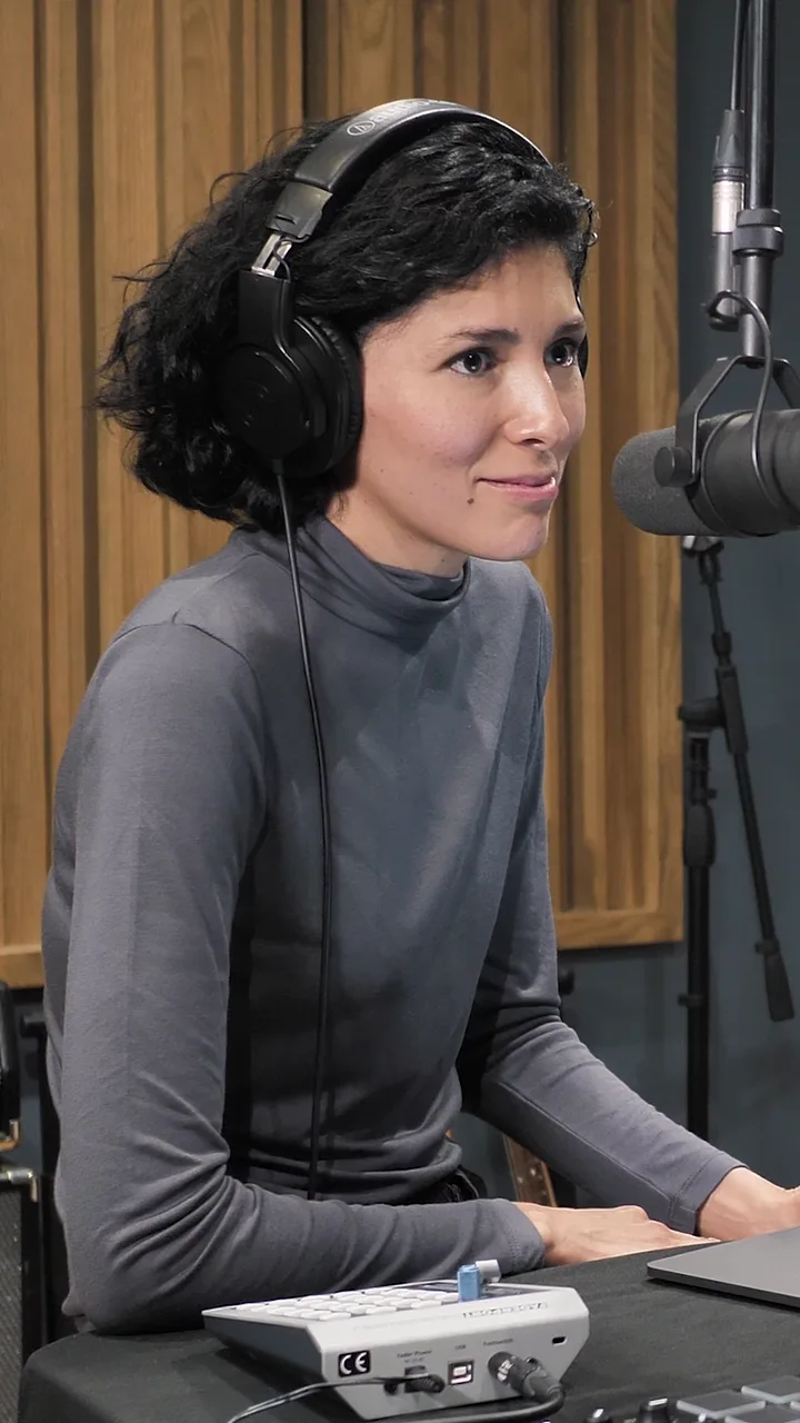 A host in headphones at a studio microphone